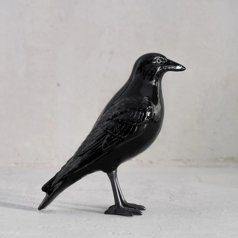 Keramikfigur einer Krähe mit schwarzen Füßen