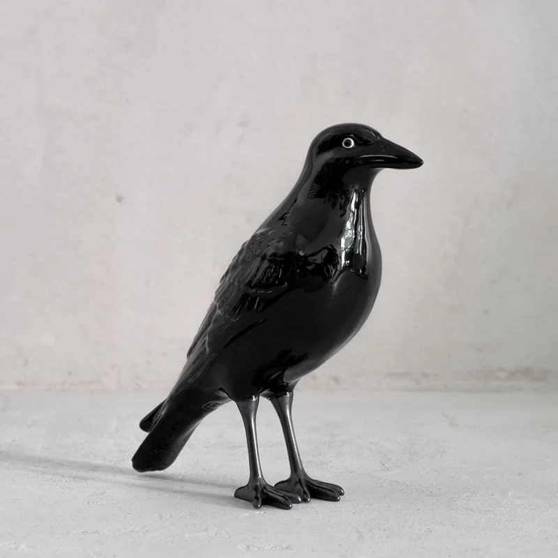 Keramikfigur einer Krähe mit schwarzen Füßen
