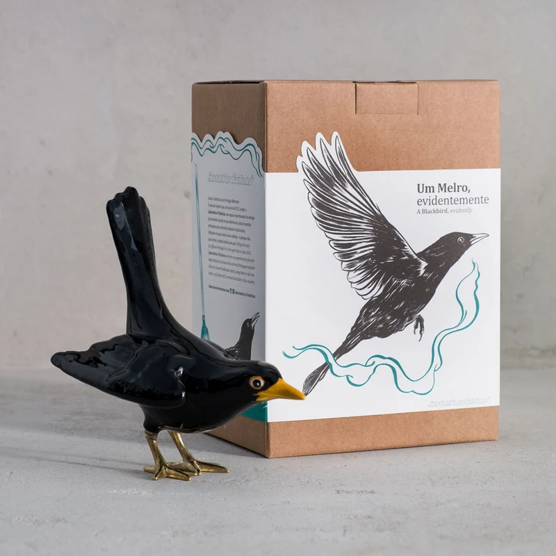Amsel mit Messingbeinen und offenen Flügeln