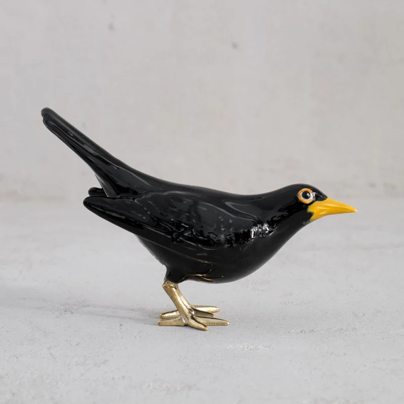 Amsel mit Messingfüßen und vertikalem Schwanz