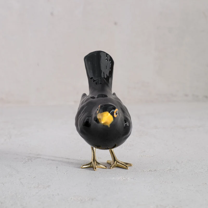 Amsel mit Messingfüßen und vertikalem Schwanz